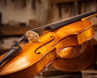 Violín personalizado con barniz ámbar y puente ajustado en el taller